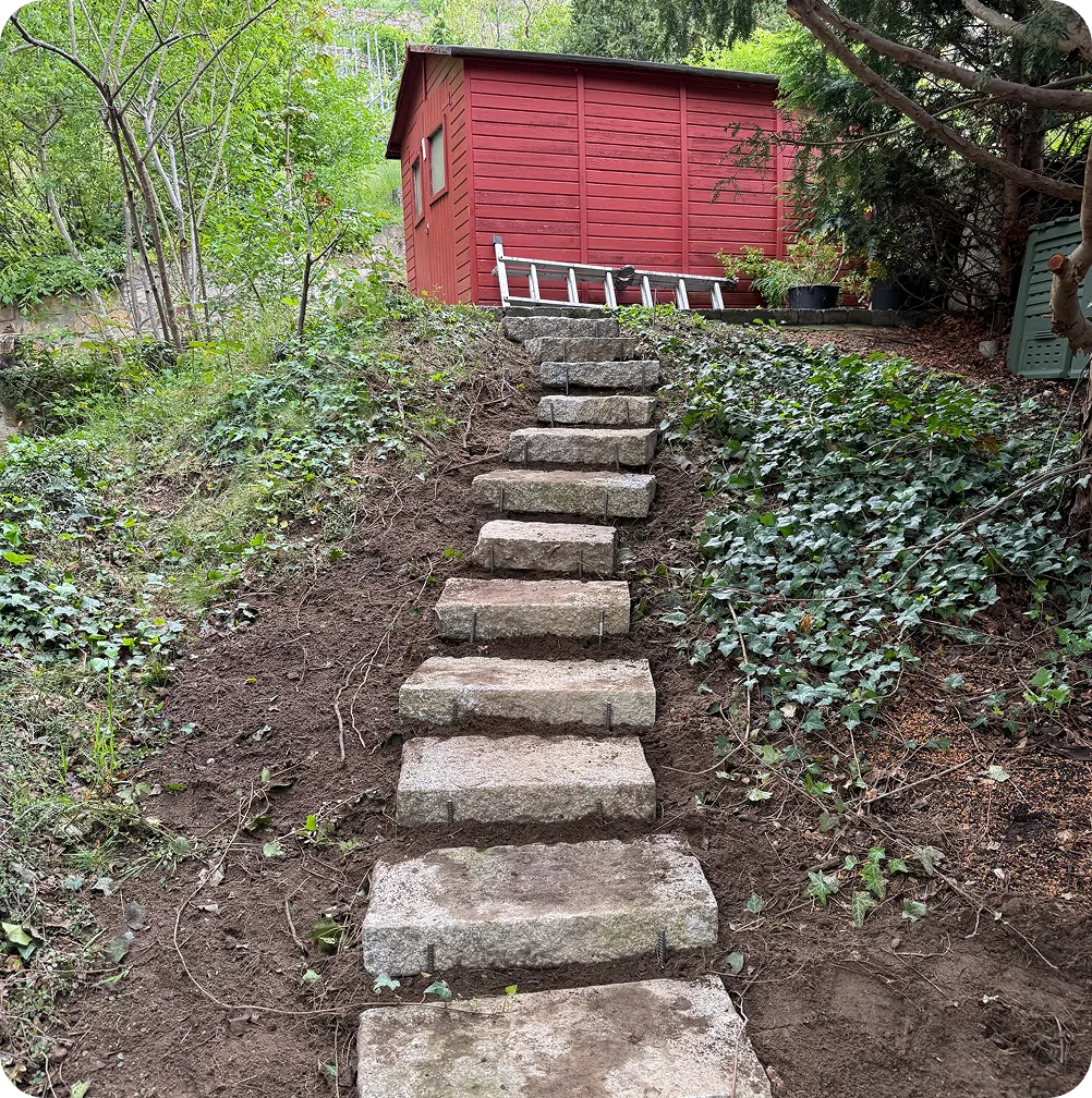 Nachher: Treppe aus Granitblockstufen durch den Efeuhang zum Gartenhaus