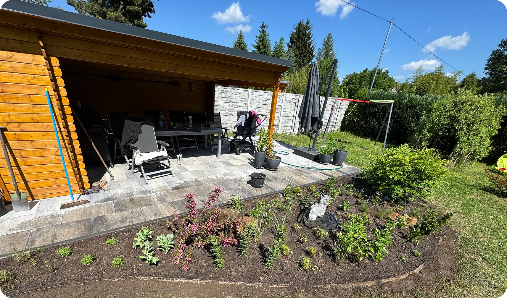Nachher: frisch bepflanztes Beet vor Terrasse und Holzpavillon